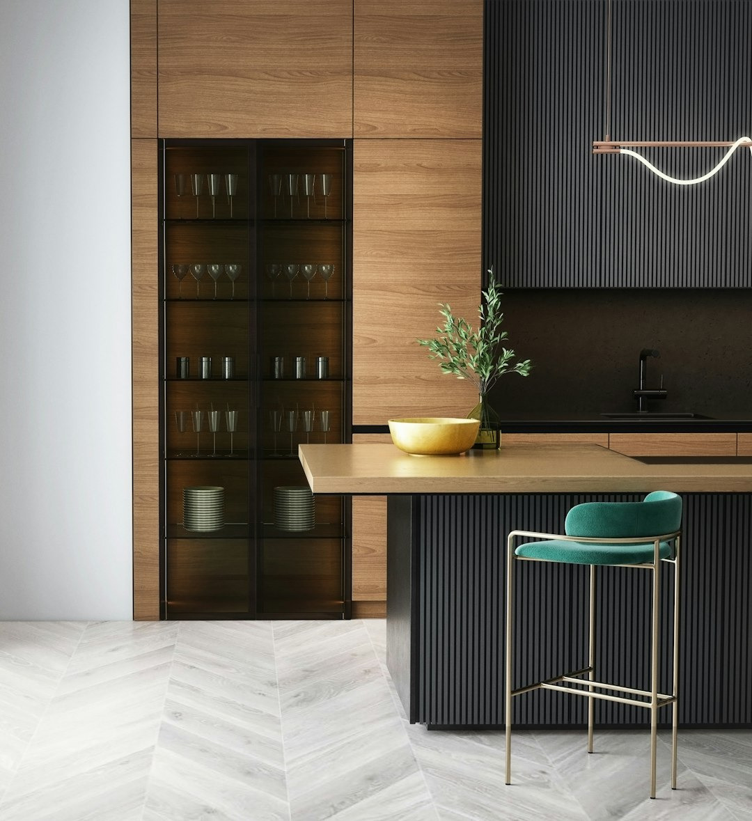 a picture of a ultra modern kitchen with Oak coloured horizontal grain doors, a glass door display larder and a grey louvred door island unit